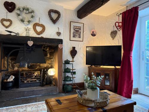 un soggiorno con tv e camino di The Buttoned Hearth in Ullswater a Penrith