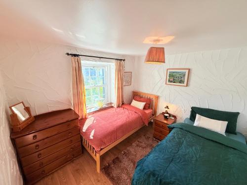 una camera da letto con un letto rosso e una finestra di The Buttoned Hearth in Ullswater a Penrith