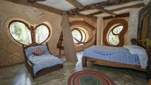 a bedroom with two beds in a room with windows at Portal Xibalba in Playa del Carmen