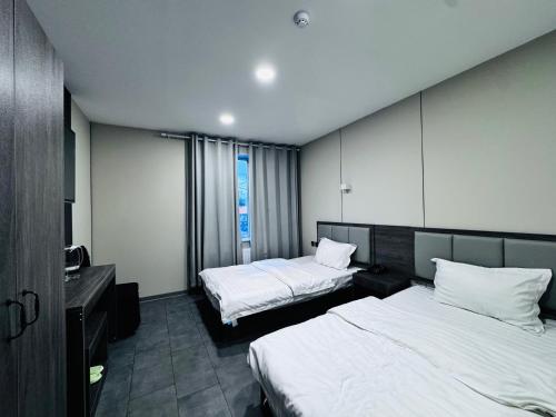 a hotel room with two beds and a desk at Lofty Hotel in Ulaanbaatar
