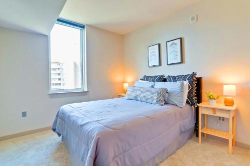 Spacious Apartment w Rooftop Views في أرلينغتون: غرفة نوم بها سرير ونافذة