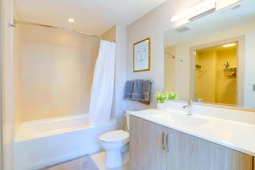 Spacious Apartment w Rooftop Views في أرلينغتون: حمام مع حوض ومرحاض وحوض استحمام