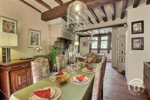 une salle à manger avec une table verte avec des chaises et une cheminée dans l'établissement Hotel des ducs de bretagne, à Saint-Brieuc
