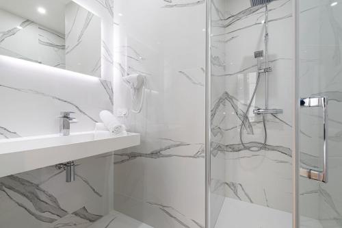 a white bathroom with a shower and a sink at Legend Majestic - Parking Privé GRATUIT- Climatisation - Gare - Centre Ville - FIBRE in Mâcon