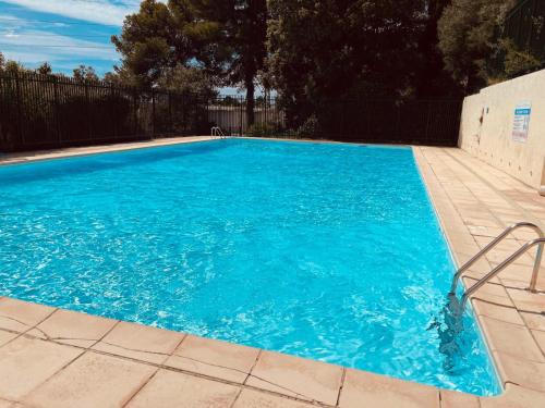 a swimming pool with blue water in a yard at Grabels, Piscine et Détente in Grabels