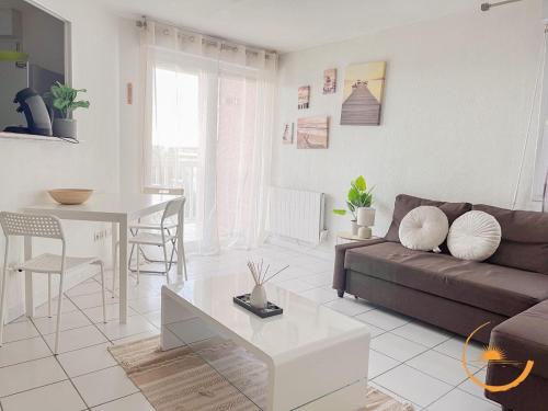a living room with a couch and a table at Grabels, Piscine et Détente in Grabels