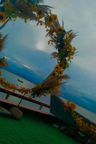 a wreath of flowers on a fence near the ocean at Pousada Do Sol Ilha do Mel in Paranaguá