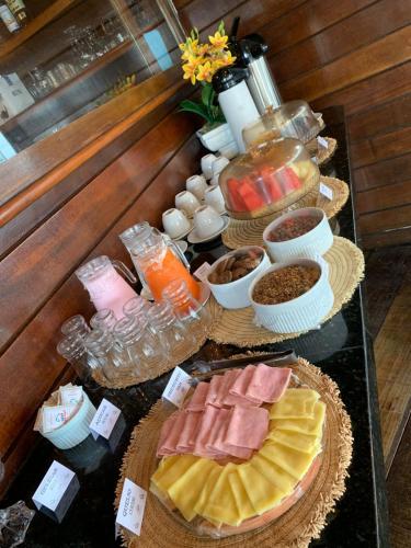 a table topped with lots of different types of food at Pousada Do Sol Ilha do Mel in Paranaguá