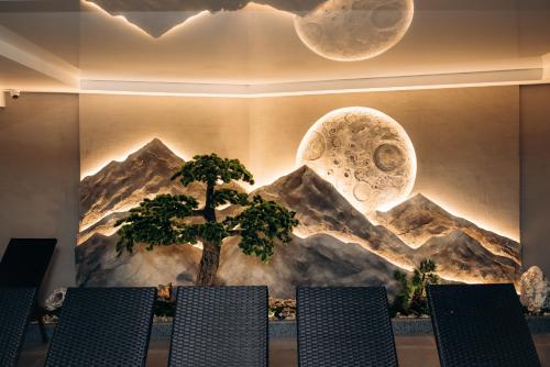 a wall with a mural of a tree and mountains at GasthauS & SPA in Bukovel