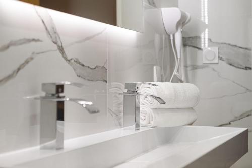 a bathroom with a sink and a mirror and towels at Legend Majestic - Parking Privé GRATUIT- Climatisation - Gare - Centre Ville - FIBRE in Mâcon