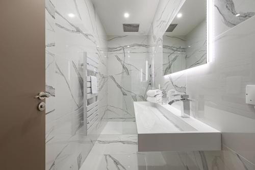 a white bathroom with a sink and a mirror at Legend Majestic - Parking Privé GRATUIT- Climatisation - Gare - Centre Ville - FIBRE in Mâcon