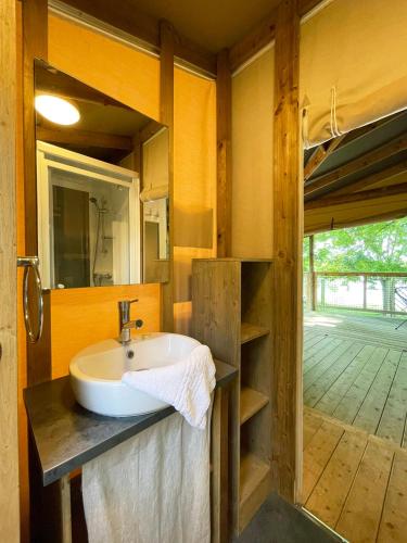 La salle de bains est pourvue d'un lavabo et d'un mur en bois. dans l'établissement Village loisirs de Goule, à Bessais-le-Fromental