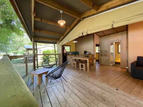 una veranda con tavolo e sedie su una terrazza di Village loisirs de Goule a Bessais-le-Fromental