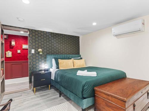 华盛顿The Speakeasy Suite A Petworth Hidden Gem的一间卧室设有绿色的床和红色的墙壁