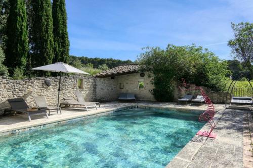 - une piscine avec un parasol en face d'une maison dans l'établissement Escapade romantique en Drôme, vue sur les vignes, à Solérieux