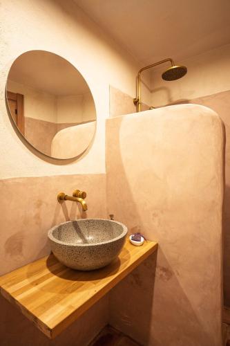 a bathroom with a stone sink and a mirror at Borda Viñuels in Planillo