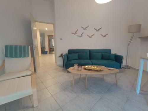 a living room with a blue couch and a table at Salamina Azuro in Selínia