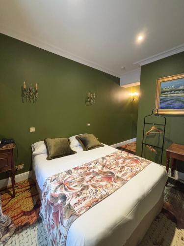 a bedroom with a large bed in a green wall at Hotel De La Poste in Langres