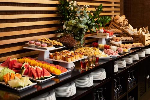 a buffet with many different types of food on plates at NH Alcorcón in Alcorcón