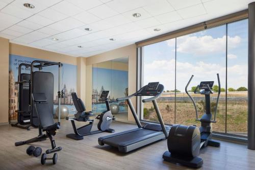 a gym with cardio equipment and a large window at NH Alcorcón in Alcorcón