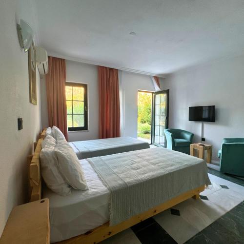 a bedroom with a large bed and a chair at Club Mel Holiday in Ortaca
