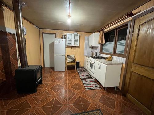 a kitchen with a refrigerator and a stove at Cabañas Encanto Quenacano 