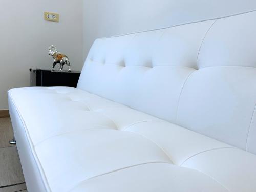 a white couch in a room with a dog on a table at Annarè House in Ischia