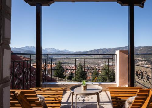 a balcony with chairs and a table and a view at Tilemachos by GM Luxury Suites Kalavryta in Kalavrita