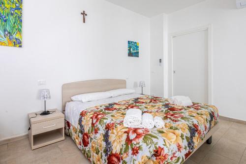a bedroom with a bed with a floral bedspread at Congregazione Suore Figlie di San Francesco di Sales in La Spezia