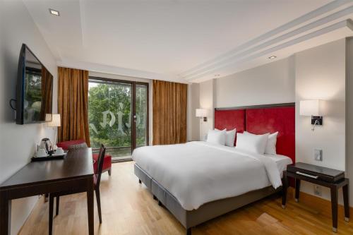 a bedroom with a large white bed and a desk at Radisson Blu Elizabete Hotel, Riga in Rīga