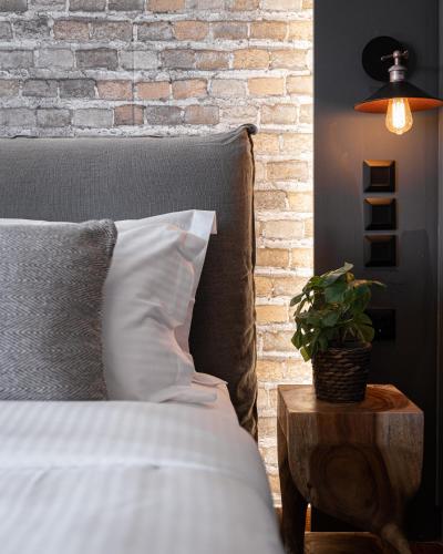 a bedroom with a bed and a brick wall at Tilemachos by GM Luxury Suites Kalavryta in Kalavrita