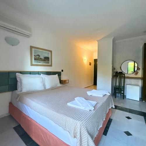 a bedroom with a large bed with white sheets at Club Mel Holiday in Ortaca