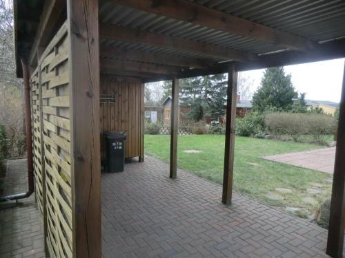 a covered patio with a trash can and a building at Zinnowitz, Kneippstr 24 b in Zinnowitz