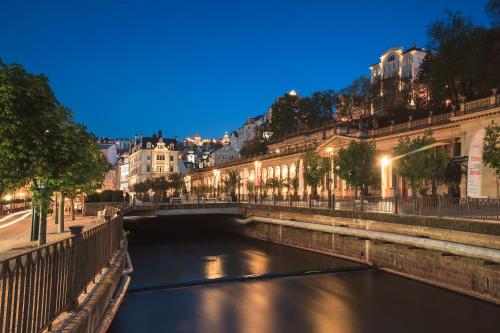 a river in a city at night at Hotel Ontario in Karlovy Vary