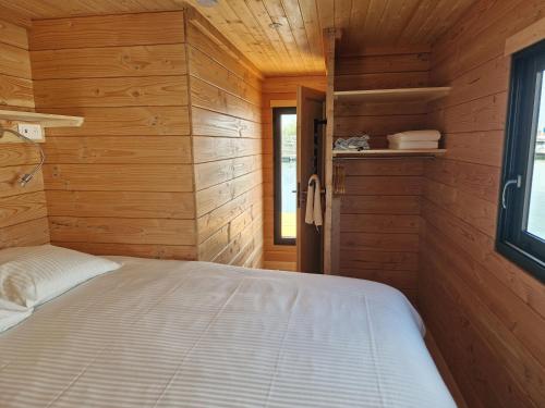 a bedroom with wooden walls and a bed in a room at Bateau panoramique sans permis Lac du Der - Eclaron in Sainte-Livière
