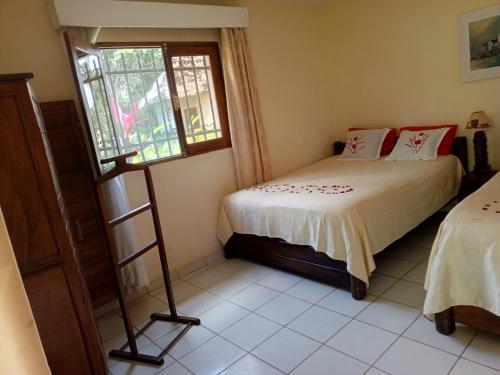 a bedroom with a bed and a window at Indri Lodge in Andasibe
