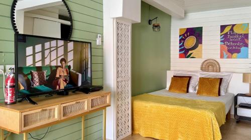 a bedroom with a bed and a mirror at Le Maracuja - Jacuzzi privé à 2 min de la plage in Sainte-Anne