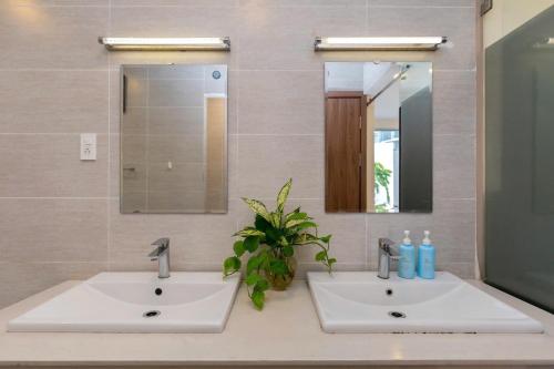 a bathroom with two sinks and a mirror at ARIA Resort Vung Tau S01 in Vung Tau