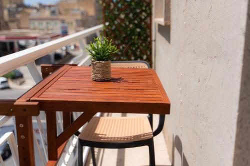 a wooden table with a potted plant on a balcony at 5 Stars - Exclusive Luxury Suites with a jacuzzi in Trapani