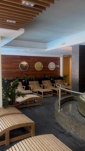 a hotel lobby with chairs and tables and mirrors at Bassiana Hotel és Étterem in Sárvár
