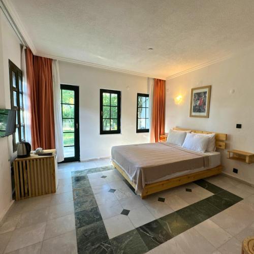 a bedroom with a large bed and some windows at Club Mel Holiday in Ortaca