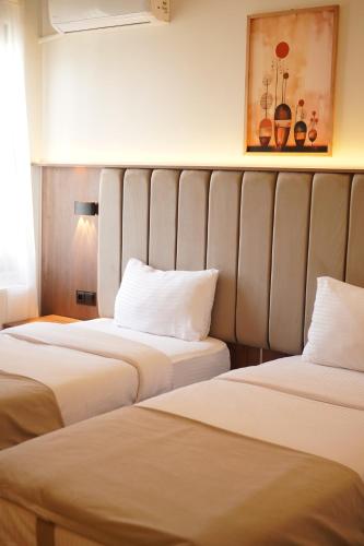 two beds sitting next to each other in a room at Lioncity Hotel in Bursa