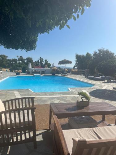 a swimming pool with a table and chairs next to it at Casa Paros in Parikia