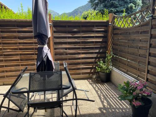 - une table et des chaises sur une terrasse avec un parasol dans l'établissement Appartement duplex Passy, à Passy