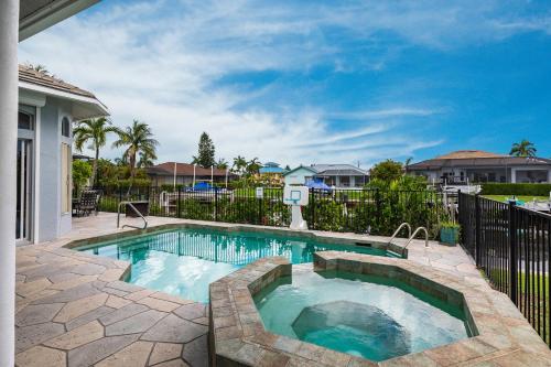 a swimming pool in a yard with a fence at Marco Island Majesty in Marco Island