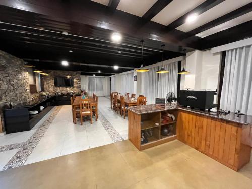 a living room with a table and chairs and a kitchen at Manali Se - Your Home in the Pines in Jagatsukh