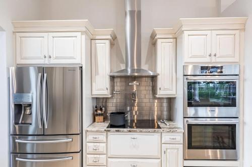 a kitchen with white cabinets and stainless steel appliances at Marco Island Majesty in Marco Island