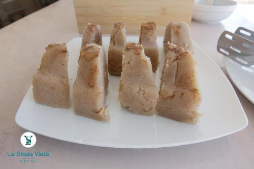 a white plate with five pieces of cake on it at La SkalaVista in Skala Kefalonias