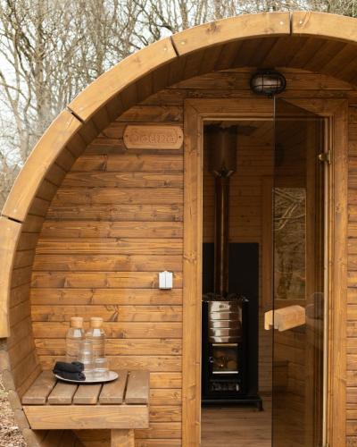 a wooden sauna with an open door with a stove at The Bulls Head Wild Cabins in Hereford