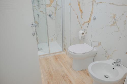 a bathroom with a toilet and a shower and a sink at SK Barigau in Lanusei